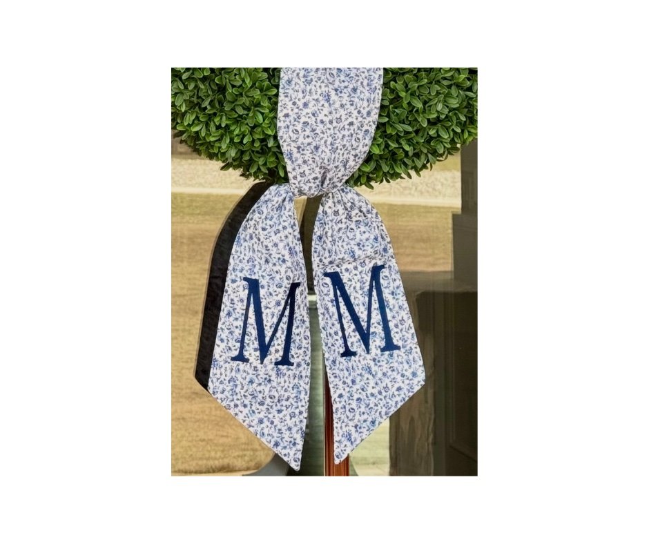 Blue floral wreath sash with navy block M monogram on a boxwood wreath