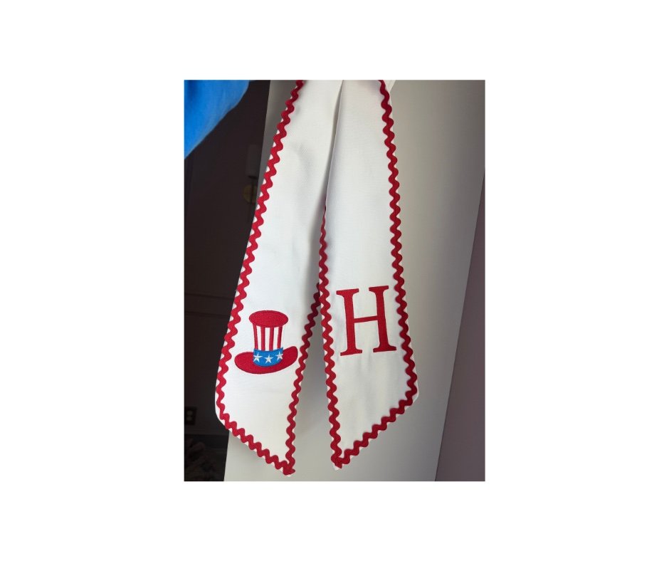 White wreath sash with red ric-rac trim, patriotic hat and H monogram