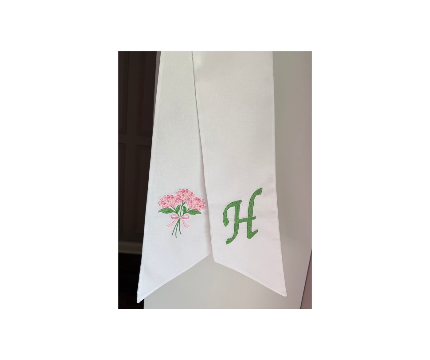 White wreath sash with pink hydrangea bouquet and green H monogram